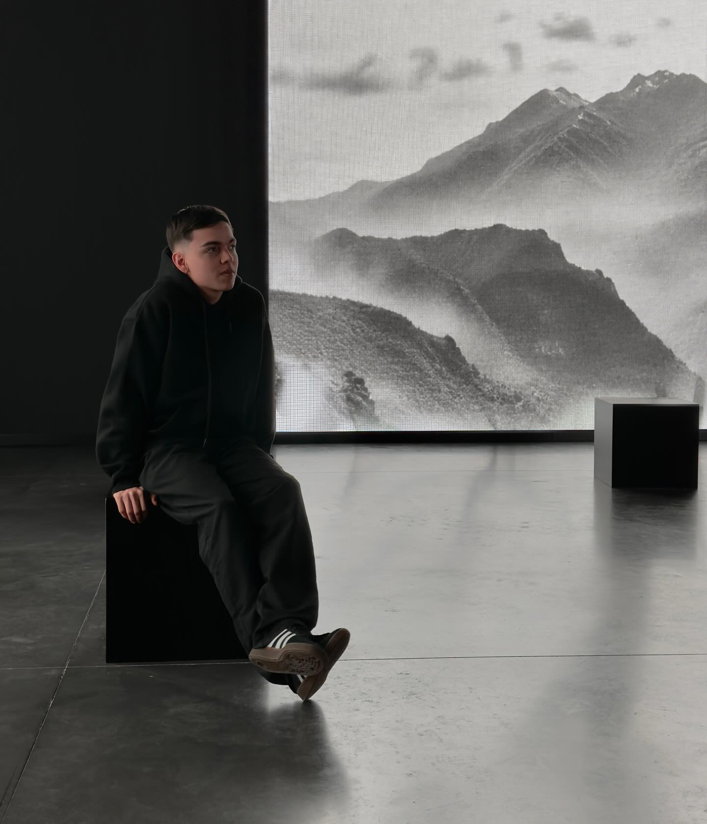 Xavier Cáceres sentado en una sala de exposición de arte contemporáneo